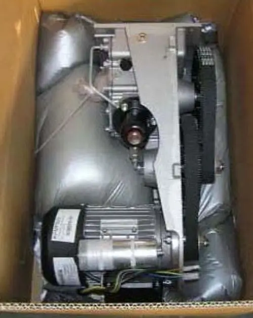 Box mit einer hydraulischen Ölpumpe von Remeha, sichtbar sind Teile der Pumpe und ein Antriebsmotor, umgeben von schützendem Material.
